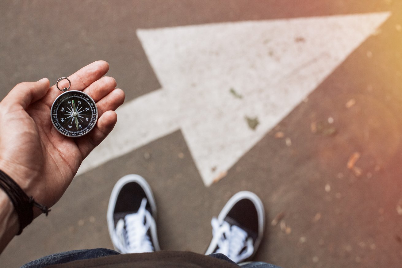 Traveler holding compass in the hand making choice